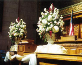 Large alter bouquets grace the assembly chamber